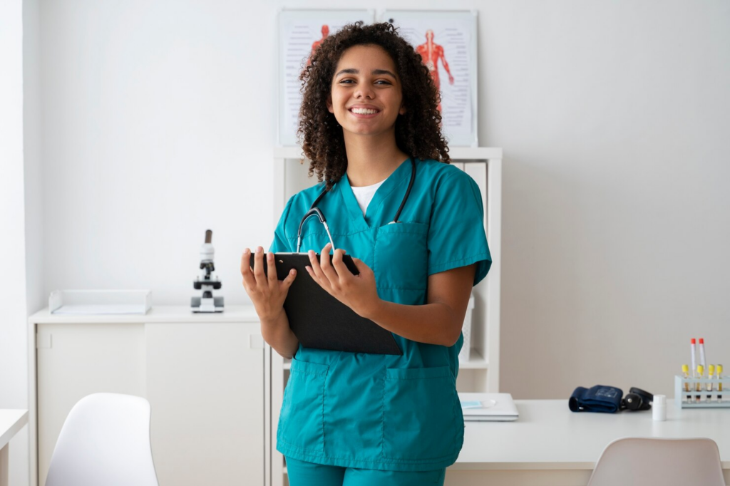 Healthcare professional with a clipboard smiling in a primary care setting.