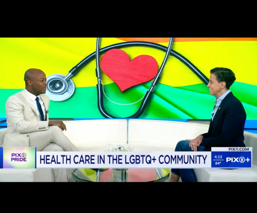 Two individuals discuss healthcare in the LGBTQ+ community on a PIX11 news segment. A rainbow flag with a heart and stethoscope graphic is in the background. A news ticker shows the time and temperature.